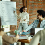 Smiling African American businesswoman talking to her Team collaborating. 